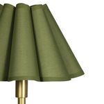 Close-up showing texture and fabric details of green scalloped lamp shade