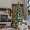 full living room scene with tall Christmas tree, fireplace with stockings, and light-colored furniture by large windows