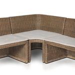 Front corner detail with focus on the curved rattan frame and fabric cushions meeting at the bend