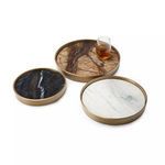 Round brass tray with brown marble inlay holding a glass with amber liquid