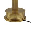 Detail of polished brass lamp base showing smooth and grooved circular sections and power cord