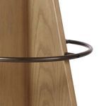 Close-up of wood base showing natural grain and metal circle footrest in dark bronze finish