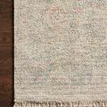 Navy and ivory hand-woven modern rug with tonal geometric pattern and fringed edges on dark wood floor