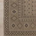 Close-up of a rug corner laying flat to show detailed pattern and tightly wrapped edges.