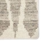 Close-up of thick wool texture and detailed Moroccan knot pattern in gray on ivory background