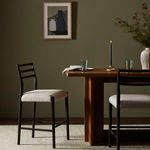 Counter stool shown in a dining room setting beside a wooden table with lighting and décor