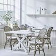 Set of six Rossini rattan dining armchairs around white cross-legged table in bright coastal dining room