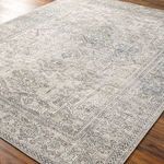 Margot rug displayed angled on hardwood floor showing low-medium pile and woven texture