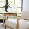 Retreat end table styled with white vase, decorative shell, artwork, and book on top in bright room.