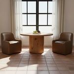 Two Maisie Rolling Dining Chairs paired with a round wooden dining table in a sunny room