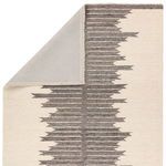 Backside view with corner flipped to reveal rug backing and inner gray pattern continuation