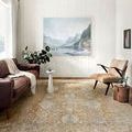 Rug styled in bright living room with white walls, brown leather couch, and nature painting above sofa