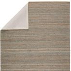 Back side of rug with one corner flipped to reveal plain natural fabric backing