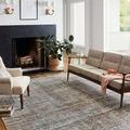 Rug in living room setting with mid-century modern sofa, fireplace, and large plant