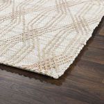 corner of rug on dark wood floor highlighting edge finish and subtle pattern variation
