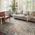 Saban Blue Spice rug styled under seating area in cozy bright living room with neutral sofa and large windows