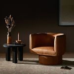 Palermo cognac leather swivel chair styled next to black side table with candle and dried flowers