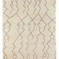 Cream Moroccan hand-knotted rug with dark geometric zigzag lines, plush texture