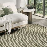 rug styled in living room setting under couch with white upholstery and green decorative pillow