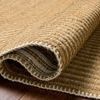 Close-up angled view showing the hand-woven texture and stitching details at the rug fold