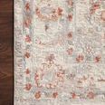 Detailed close-up of the rug’s rust and blue motifs along the border against a dark wood floor
