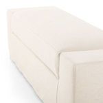 Angled side view emphasizing the bench's solid arm and thick cushion with slipcover
