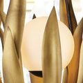 Close-up of frosted white glass globe light surrounded by brass-finished metal leaves