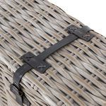 Detailed view of leather closure strap fastened across rattan weave