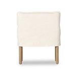 Back view of Addington dining armchair with loose linen slipcover covering solid oak legs