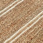 Close-up showing chunky woven texture and cream stripes of Barcelona jute rug