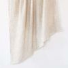 Light beige crinkled double weave linen throw with a soft textured surface and raw edges