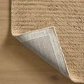 Kai Beige Rug corner flipped over revealing the woven underside with brand markings