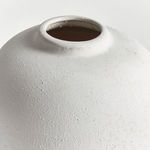 Close-up view of matte white textured surface and narrow vase opening