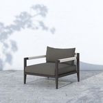 Sherwood chair outdoors on stone patio with dappled sunlight and shadow from tree branches