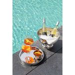 Tray placed poolside serving two Aperol spritz drinks and a bowl of chips alongside a silver ice bucket