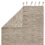 Back view of rug folded to reveal both front patterned and solid woven reverse sides