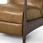 Side view close-up showing plush seating and wood armrest of warm brown recliner