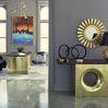 Interior scene featuring Baran Barrel Back Chair next to brass console table with decorative lamp and round mirror