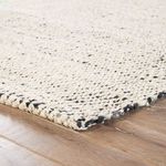 Rectangular natural fiber rug with a duo-tone white, silver, and black mottled woven jute texture