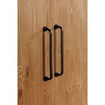 Close-up side shot of Tade cabinet black metal handles with pine wood background