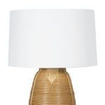 Detail view of woven rattan base with light brown vertical ridges and curves under white shade