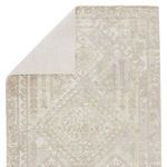 Rug flipped corner revealing solid cream woven backing fabric on the reverse side