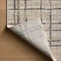 Rug corner folded to display the underside's lighter color and woven texture.