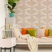 Living room wall with paper cranes wallpaper behind a daybed with colorful pillows and decorative plants