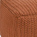 Close-up of the corner seam showcasing the thick, handwoven knitted texture of the rust pouf