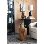 Pedestal dining table styled in a living room beside cream sofa and decorative lamp with warm beige walls