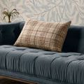 Beau Brown / Ivory Pillow resting on a tufted blue velvet sofa against a patterned wallpaper background