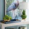 Console table adorned with green gourd lamp, floral tray, lush hydrangea, blue and green art, and patterned stools