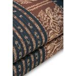 Close-up showing plush sofa back cushion with vertical stripe pattern in navy and brown