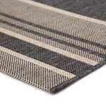 Angled view highlighting thin edge finish and subtle weave pattern in striped gray and beige tones
